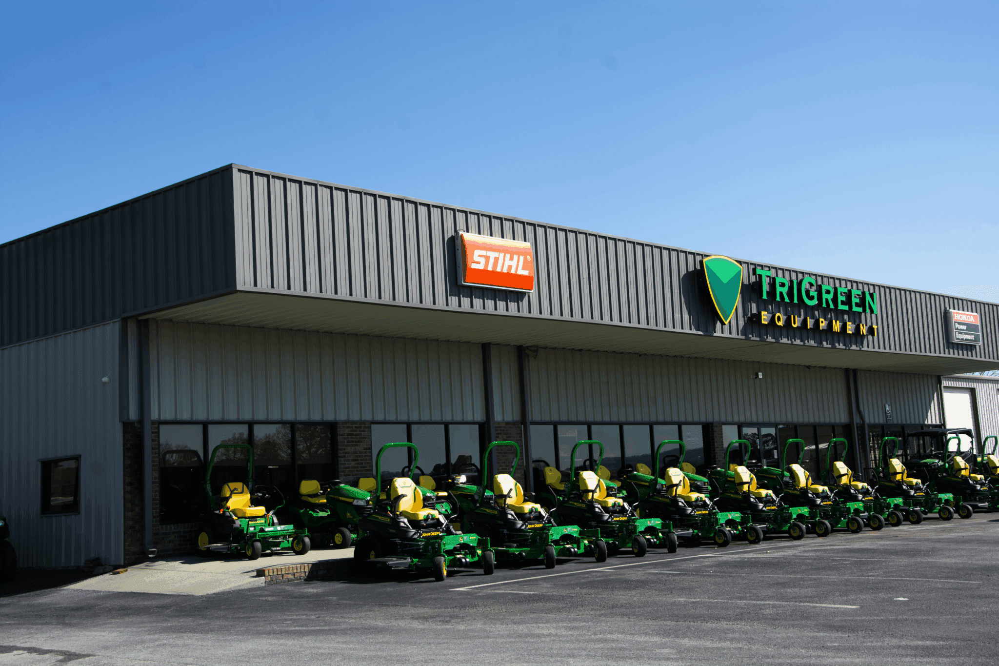 John Deere store in Snead Alabama. John Deere zero-turn mowers are lined up outside the dealership.