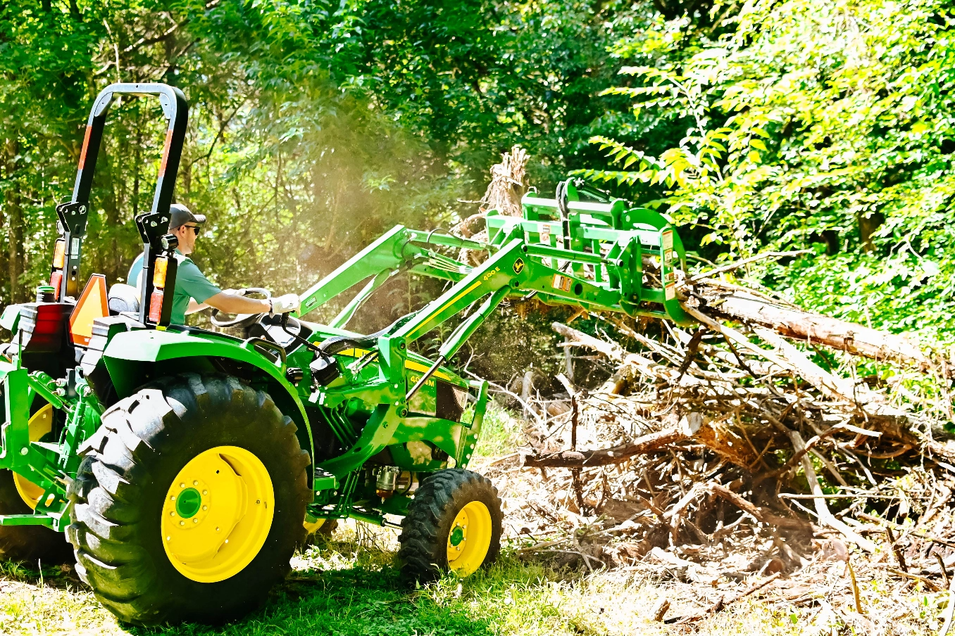 John Deere yard tractor being used to lift tree branches