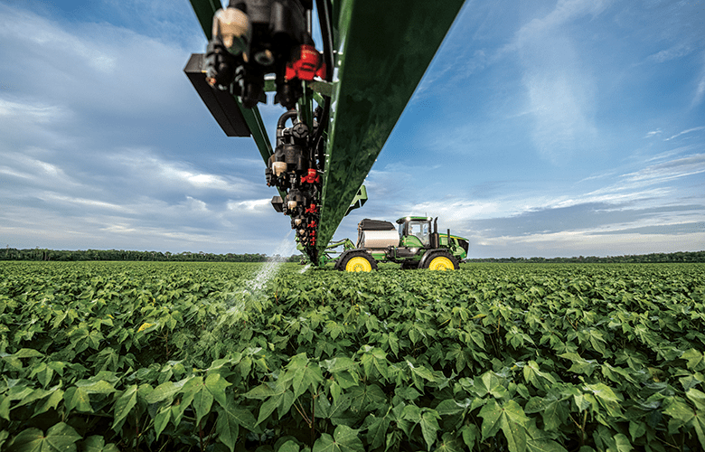 A John Deere sprayer sprays weeds in a cotton field