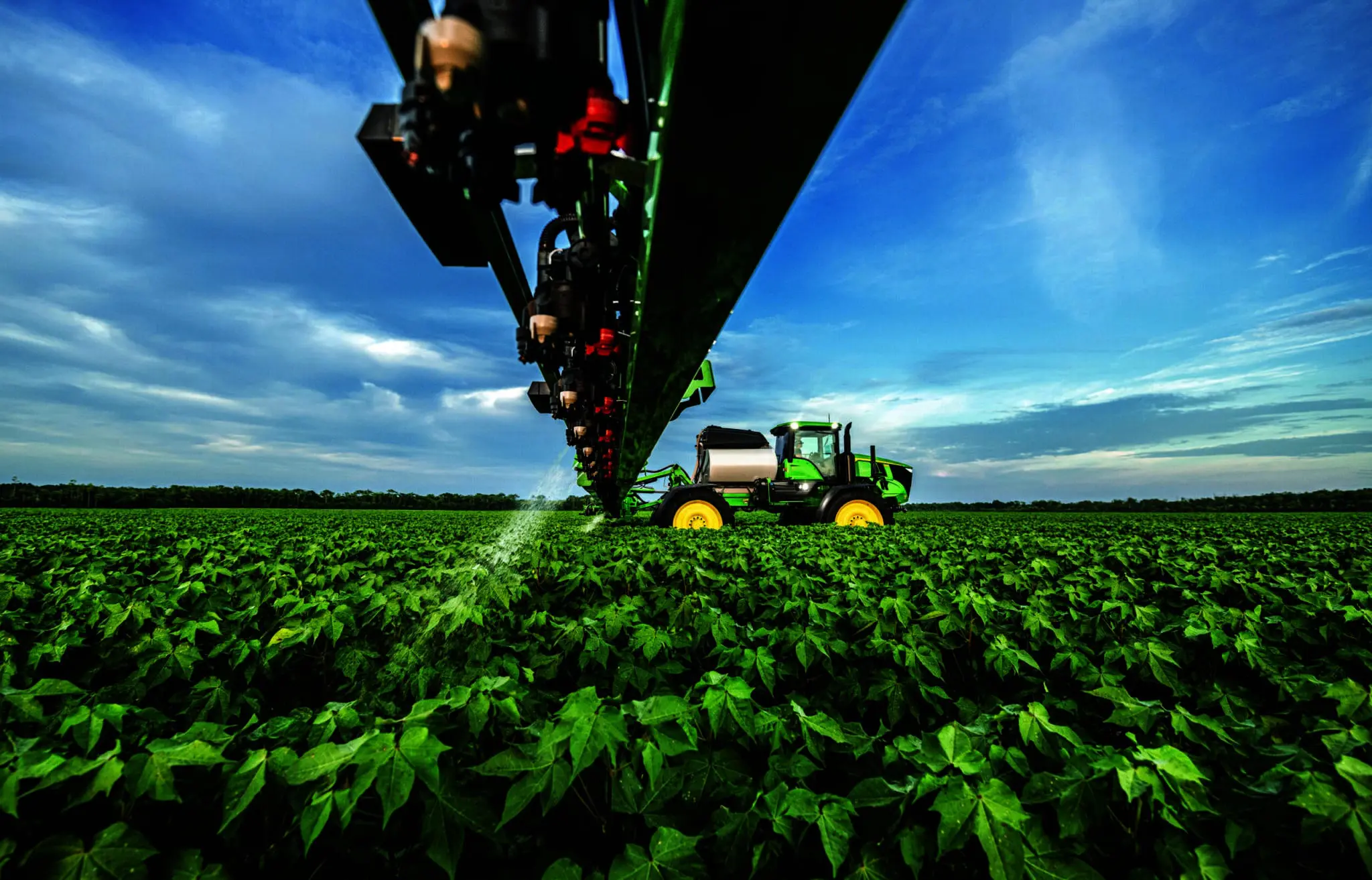 A John Deere sprayer sprays weeds in a cotton field