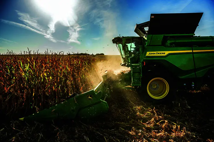 A John Deere X9 combine harvests corn.