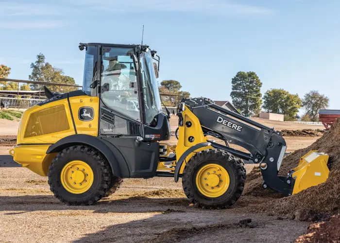 A John Deere 326P wheel loader lifts a load of dirt