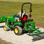 Frontier landscape rake on back of John Deere small tractor