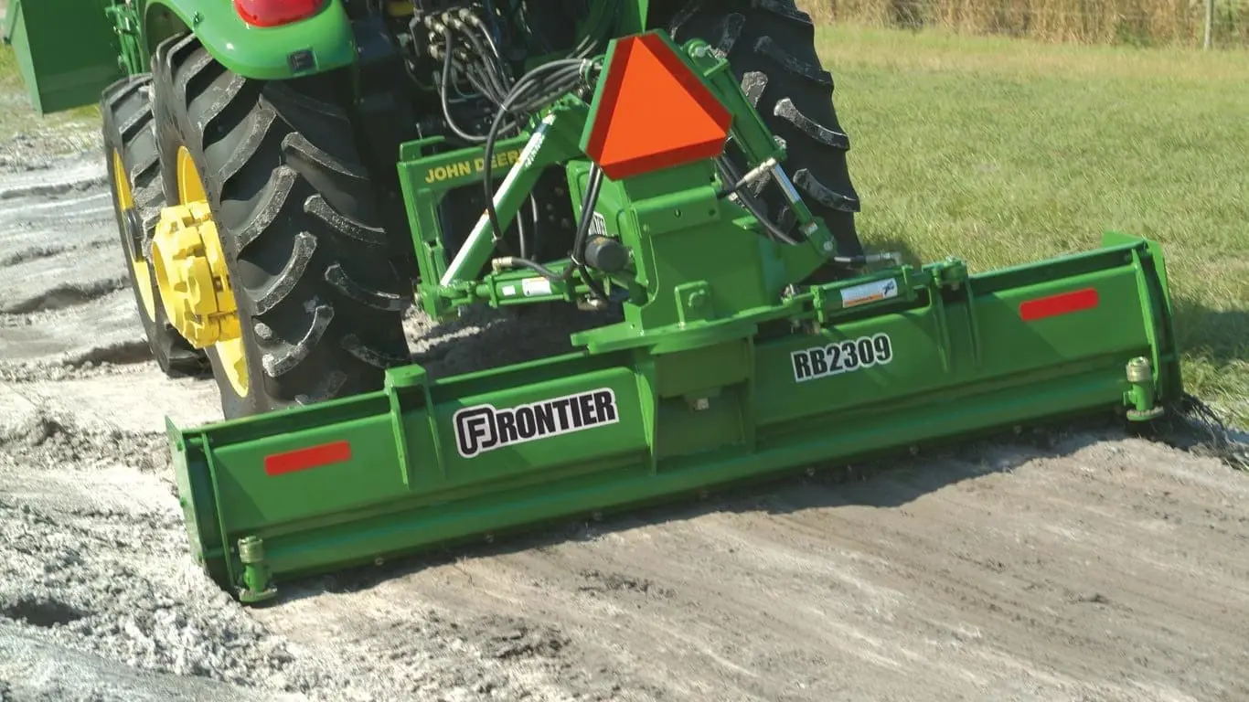 Frontier RB2309 leveling sand on back of John Deere compact tractor