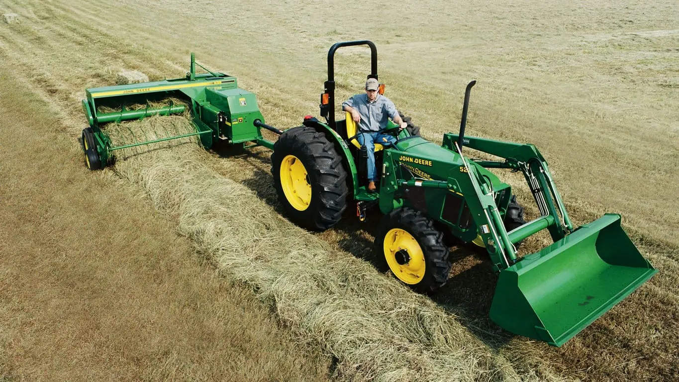 John Deere utility tractor pulls John Deere 338 square baler.