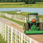 A John Deere 4044R tractor grades a drive