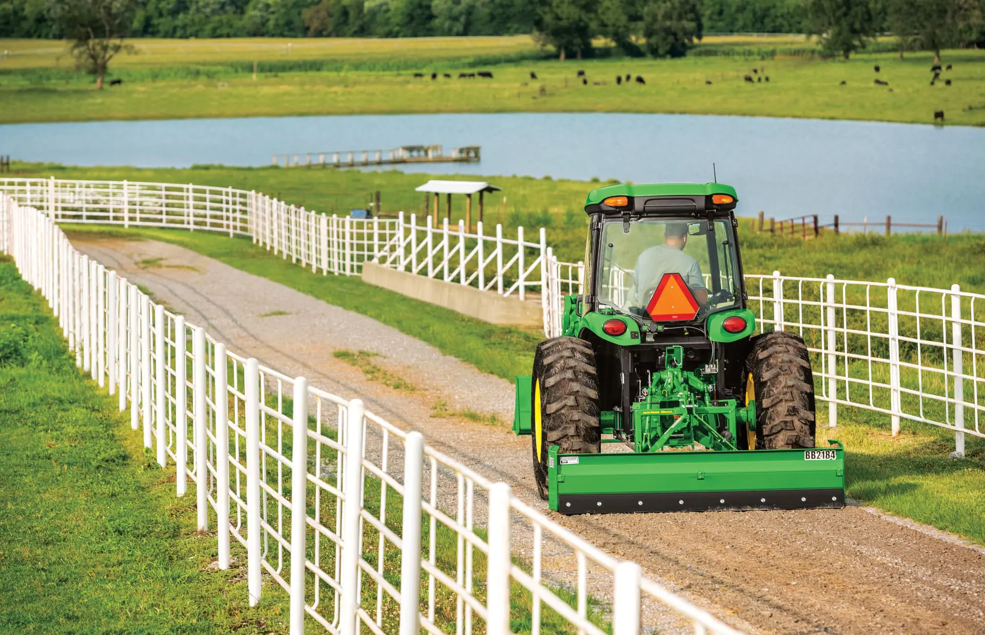 A John Deere 4044R tractor grades a drive