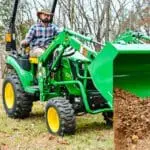 A person moves dirt with a John Deere 2R tractor and loader