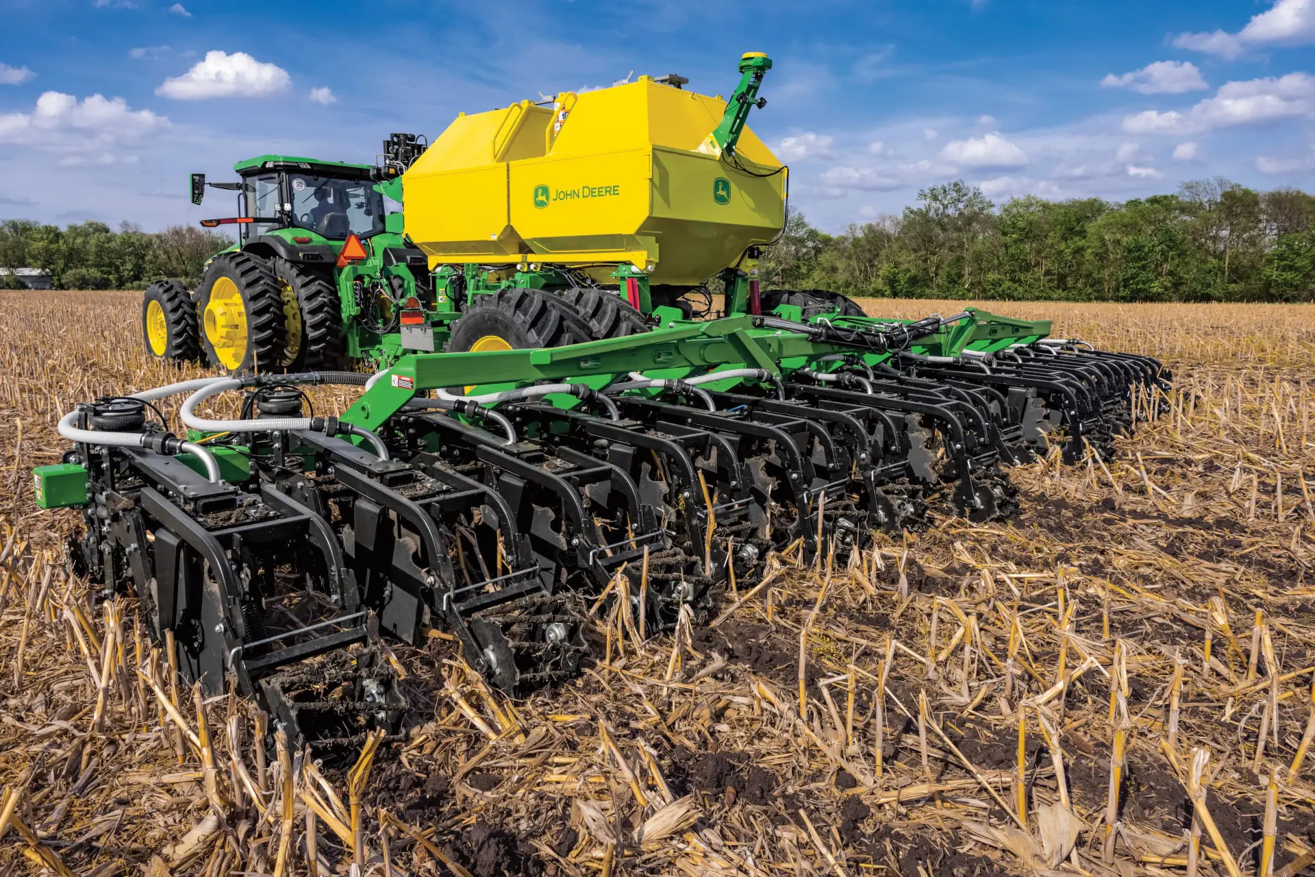 A John Deere strip till bar and tractor work in a field