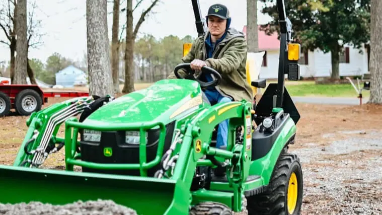 John Deere 1025R and loader moving gravel