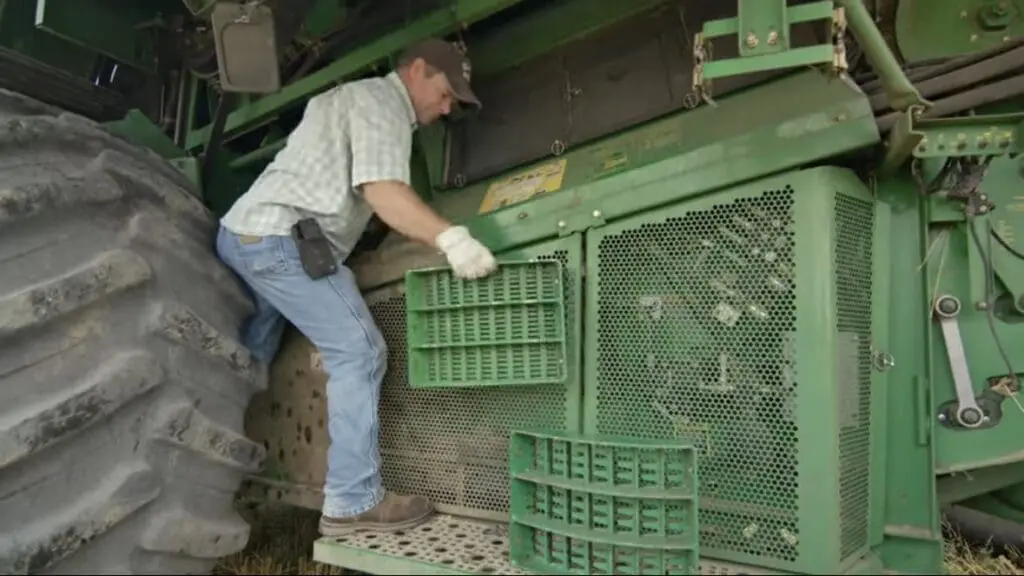 A farmer installs Bushel Plus combine parts
