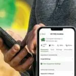 Man uses John Deere Equipment Mobile App in field
