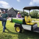 Man and woman do yard work with John Deere GX Electric Utility Vehicle