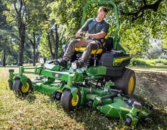 A man mows with a diesel zero turn commercial mower