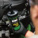 Technician changes Easy Change oil filter on John Deere lawn mower