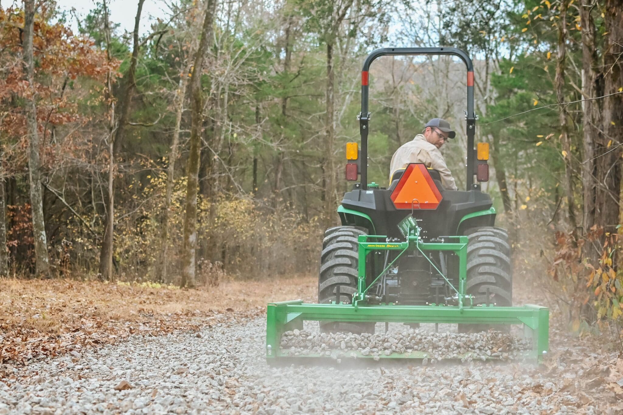 A John Deere land plane levels a gravel drive