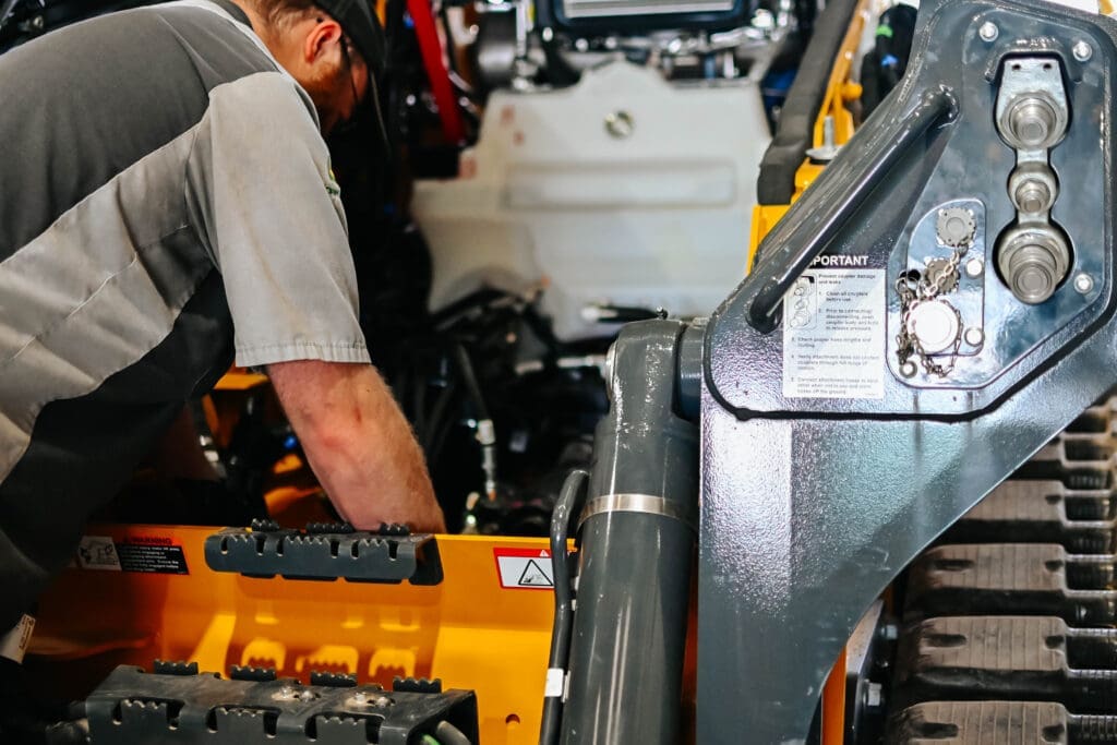 Technician servicing construction equipment
