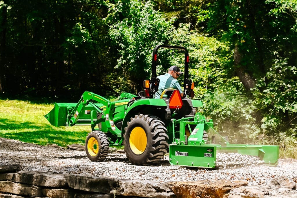Mini tractor grading gravel on a driveway