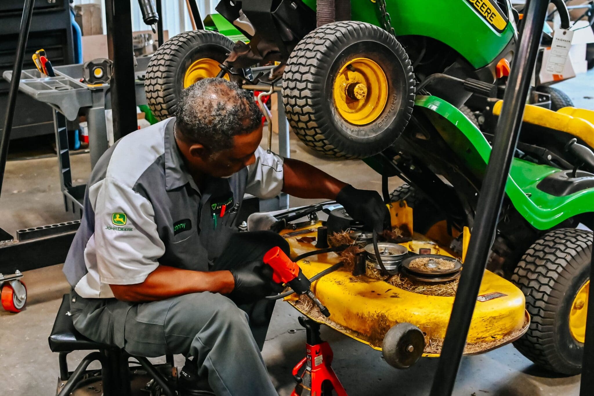 TriGreen John Deere-certified mechanic works on John Deere lawn tractor