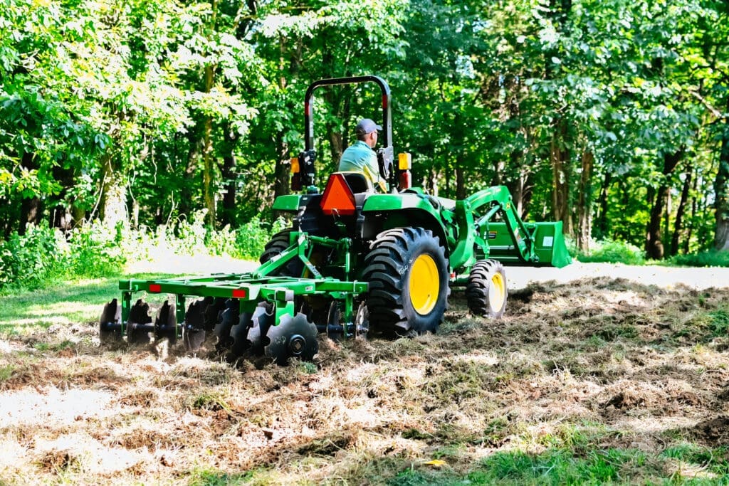 Compact utility tractor with seeder attachment