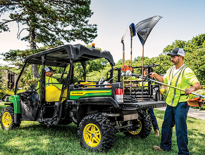 Workers unload STIHL power tools from a John Deere Gator side by side.