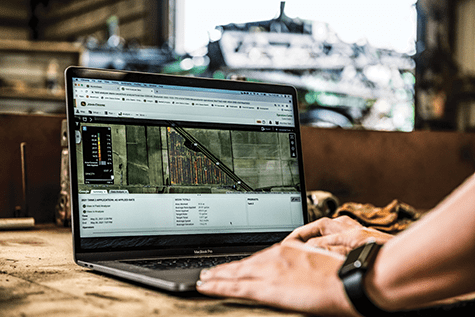 A farmer uses a computer to look at agronomic data in John Deere Operations Center