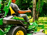 A person mows with a John Deere Z9 zero turn mower