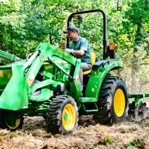 A man disks a food plot with a Deere 3035D tractor