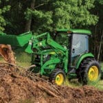 A John Deere 4052R tractor and loader move dirt from a pile