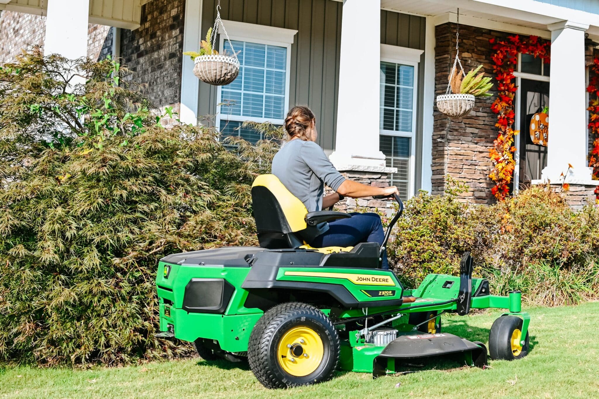 A person mows around a house with a Z370R mower