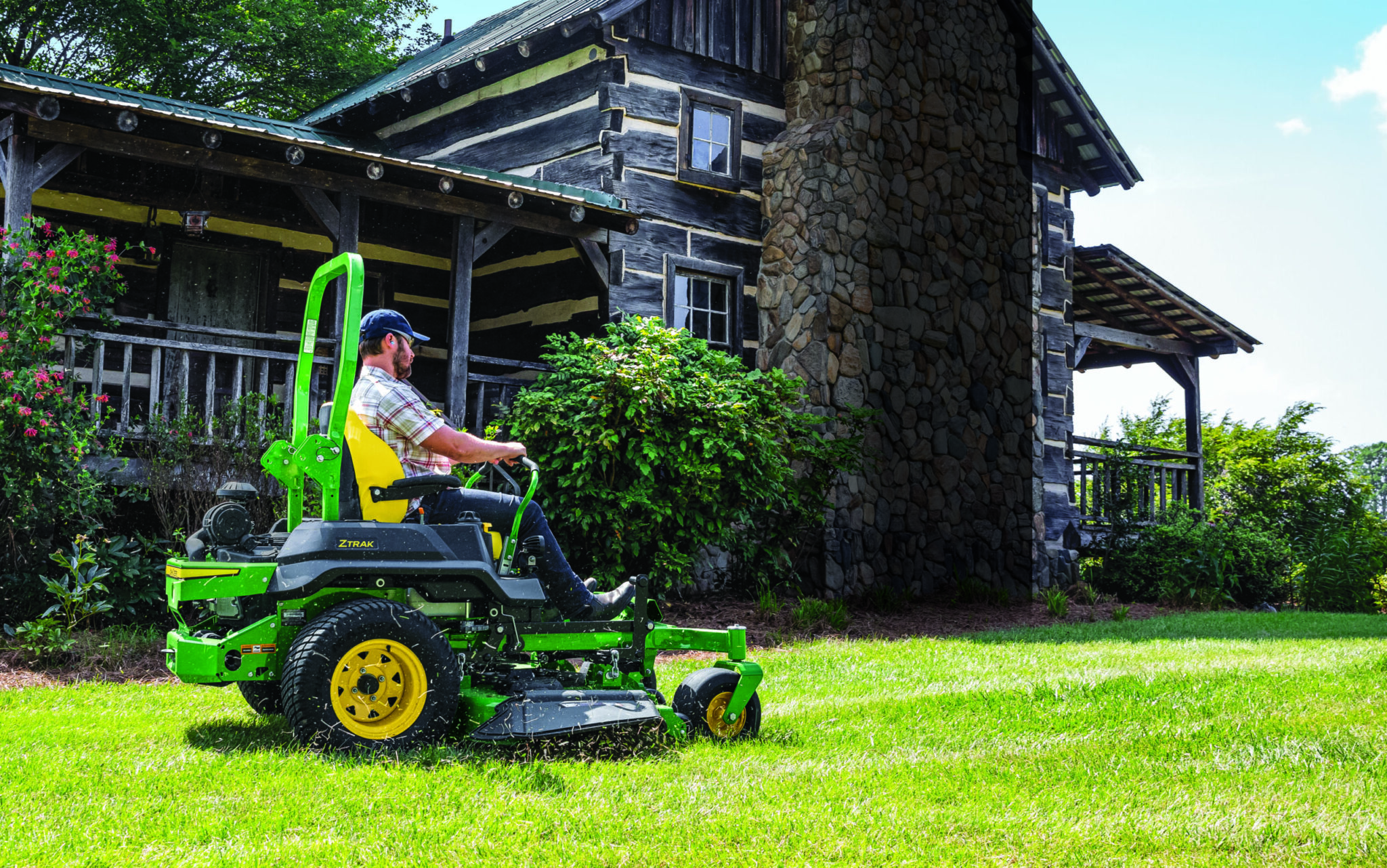 A man mows near a cabin with a Z740R mower