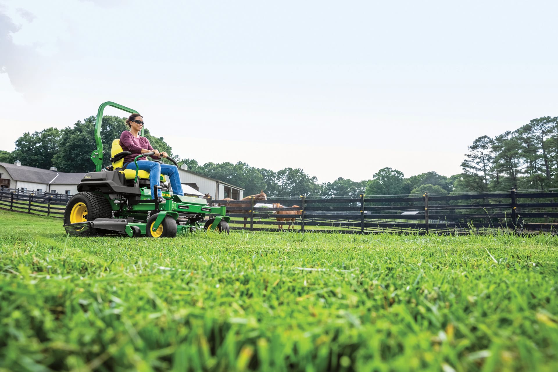 A woman mows next to a pasture with a Z700 mower