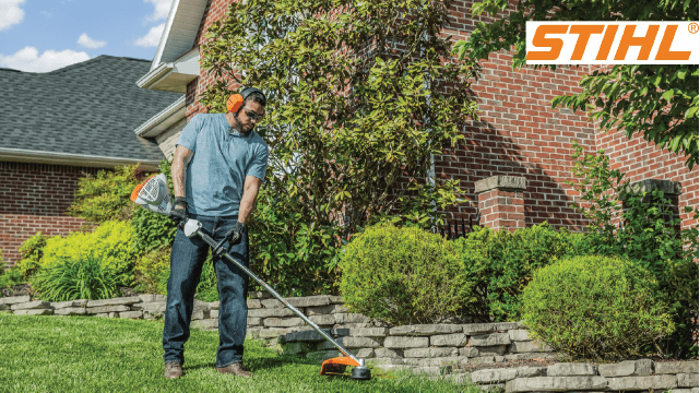 Man trims edge of stone retaining wall with STIHL string trimmer.