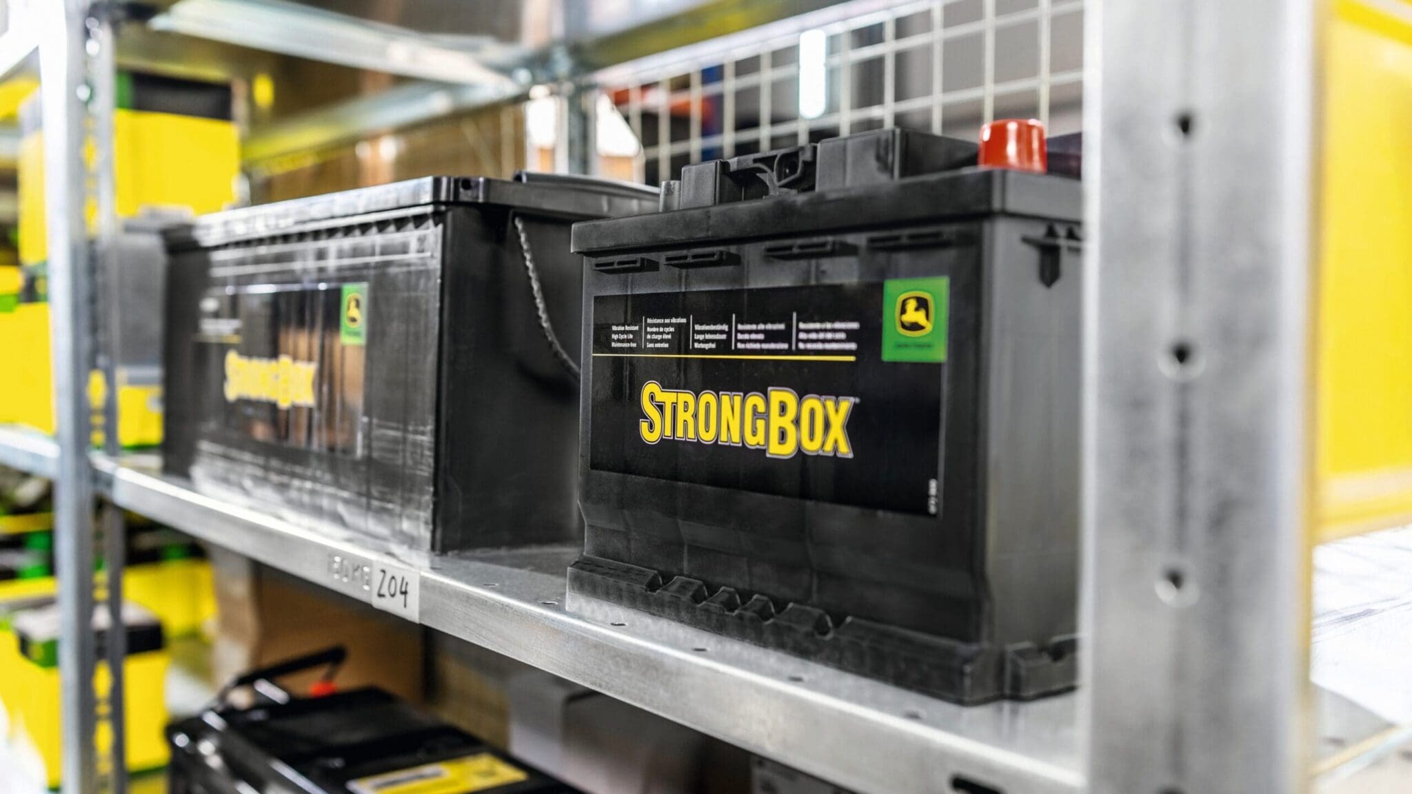 John Deere StrongBox batteries on shelf in parts storage room.