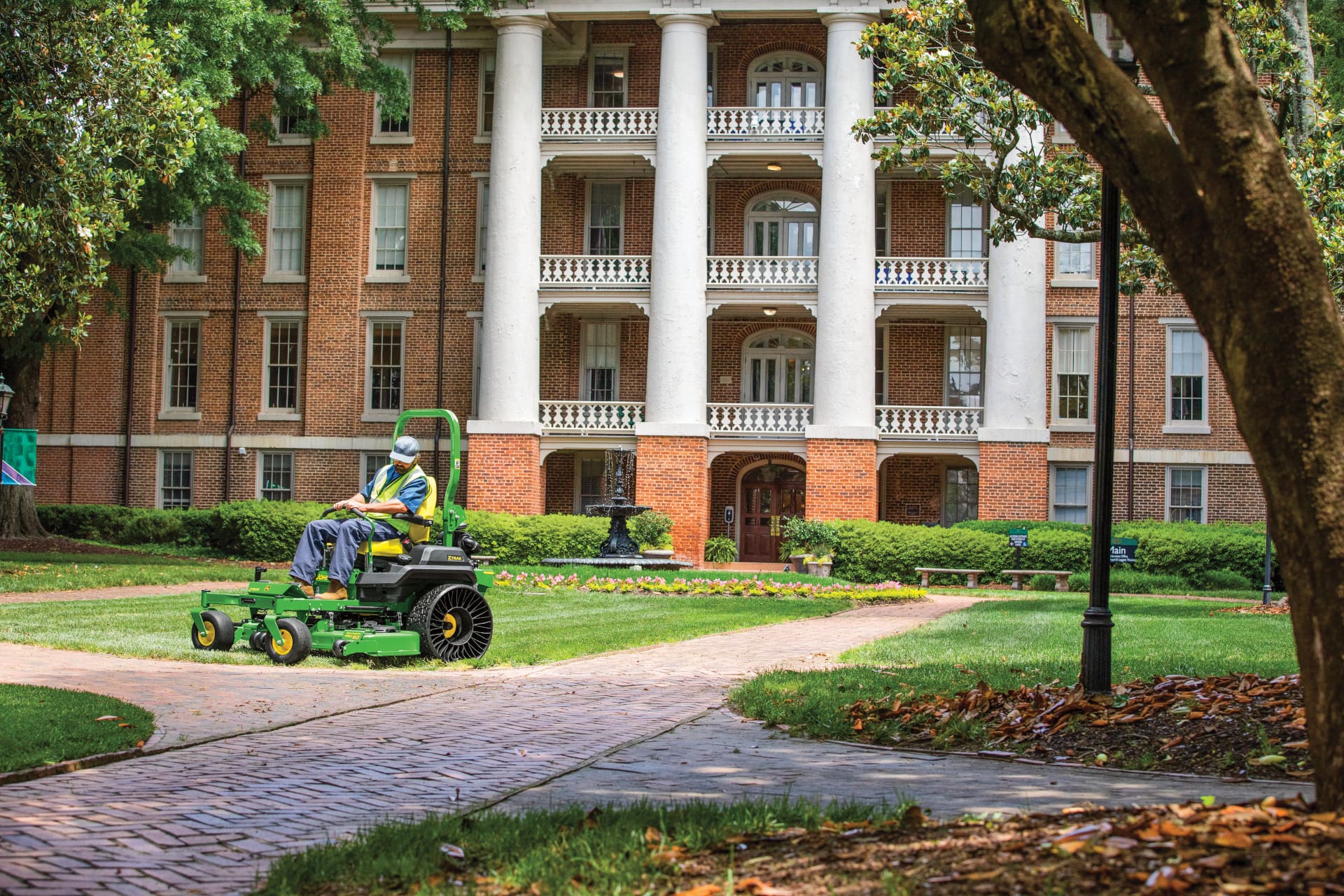 A man mows in front of a building with a Z700 series mower